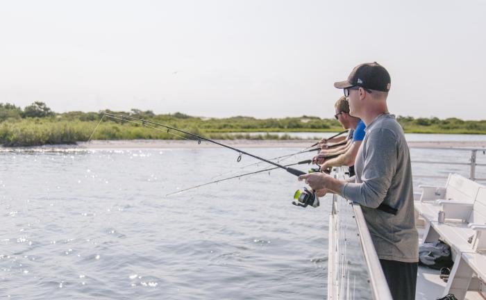 guys on boat fishing in bay