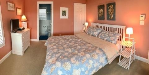 large bedroom with bed dresser and access to bathroom