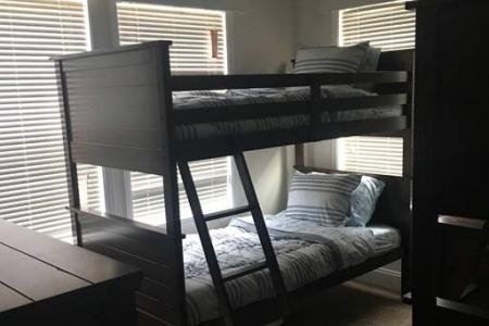 small bedroom with brown bunk beds and dresser