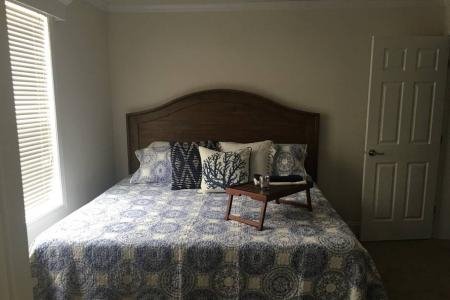 small bedroom with queen bed with headboard and window